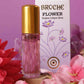 broche-flower-perfume-15ml-bottle-and-packaging-with-purple-bakground-and-beautiful-flowers